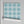 Santorini Tile wallpaper by Liberty James Studio in blue, partly unrolled roll showing a Mediterranean tile pattern