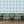 Santorini Tile wallpaper by Liberty James Studio in pale blue and white, a Mediterranean tile pattern in a living room