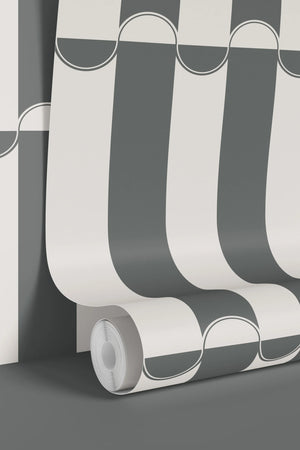 Scallop Lane wallpaper by Liberty James Studio in slate blue and cream, partly unrolled roll showing scalloped stripes