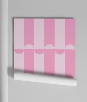 Scallop Lane wallpaper by Liberty James Studio in pink, partly unrolled roll showing scalloped stripes