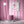Scallop Lane wallpaper by Liberty James Studio in pink, scalloped stripes behind a sofa in a living room