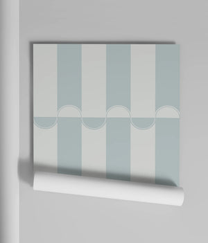 Scallop Lane wallpaper by Liberty James Studio in pale blue and white, partly unrolled roll showing scalloped stripes