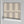 Scallop Lane wallpaper by Liberty James Studio in grey, partly unrolled roll showing scalloped stripes