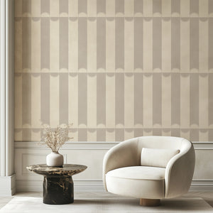 Scallop Lane wallpaper by Liberty James Studio in grey, scalloped stripes behind a sofa in a living room