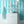 Scallop Lane wallpaper by Liberty James Studio in turquoise and white, scalloped stripes on a bathroom wall