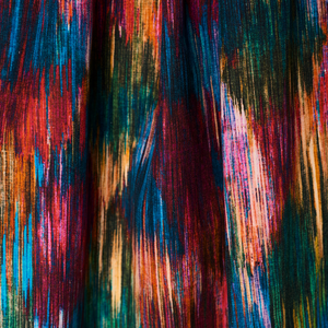 Spectre Ikat velvet by Victoria Sanders in red, blue and green, a blurred ikat design made into curtains