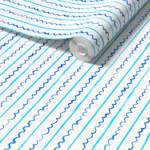 Sea Lines Stripe wallpaper by Seed Home Designs in blue and white, partly unrolled roll showing fine watercolour stripes