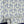 Shell Seekers wallpaper by Liberty James Studio in blue, partly unrolled roll showing a scallop shell pattern
