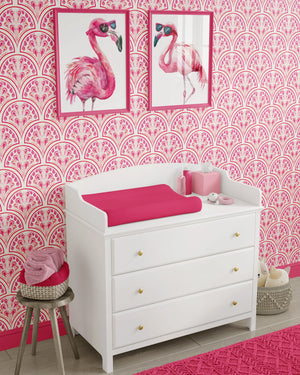 Shell Seekers wallpaper by Liberty James Studio in pink, a scallop shell pattern behind a daybed in a child's room
