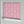Shell Seekers wallpaper by Liberty James Studio in pink, partly unrolled roll showing a scallop shell pattern