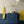Shell Seekers wallpaper by Liberty James Studio in blue and yellow, a scallop shell pattern behind a console table