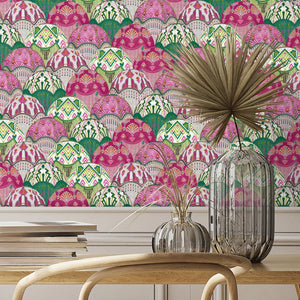 Silk Shades wallpaper by Brand McKenzie in pink, layered silk lampshades behind a dining table
