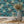 Silk Shades wallpaper by Brand McKenzie in teal, layered silk lampshades in a dining area