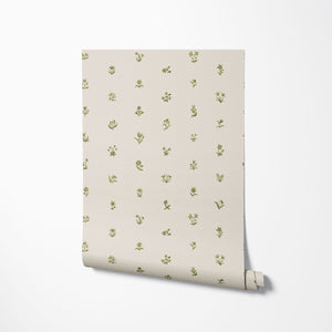 Cottage Ditsy wallpaper by Studio Le Cocq in green, partly unrolled roll showing scattered ditsy flowers