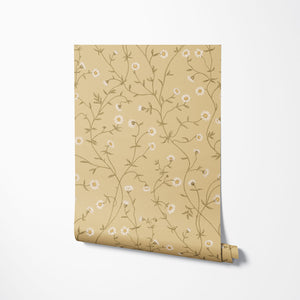 Daisy Chain wallpaper by Studio Le Cocq in yellow, partly unrolled roll showing trailing daisy chains