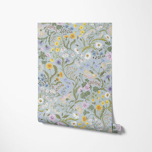 The Lost Garden in Coastal Blue wallpaper by Studio Le Cocq in blue, partly unrolled roll showing a dense garden of flowers