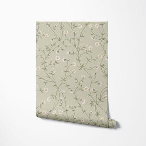 Daisy Chain wallpaper by Studio Le Cocq in sage green, partly unrolled roll showing trailing daisy chains