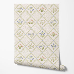 First Signs wallpaper by Studio Le Cocq in brown, partly unrolled roll showing a floral trellis