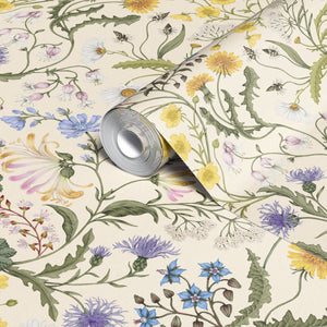 The Lost Garden Cottage wallpaper by Studio Le Cocq in cream, partly unrolled roll showing a dense garden of flowers