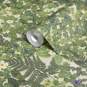 Woodland Floor wallpaper by Studio Le Cocq in green, partly unrolled roll showing woodland flowers and ferns