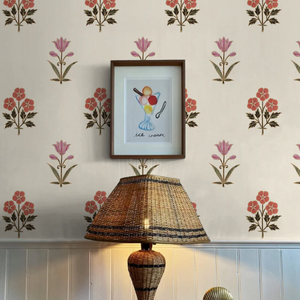 Sultana wallpaper by Deus ex Gardenia in pink and red, a vertical floral motif above a sideboard