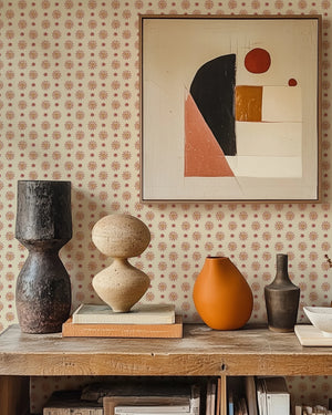 Sunshine Masquerade wallpaper by Annika Reed in cream and red, sun and mask motifs above a sideboard