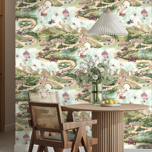 Tally Ho! wallpaper by Brand McKenzie in green, a countryside landscape behind a dining table