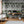The Architecture wallpaper by Brand McKenzie in grey, overgrown classical buildings behind a desk in a home office
