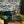 The Art Deco Hills wallpaper by Brand McKenzie in teal, Art Deco hillside scenes in a living room