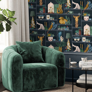 The Cabinet wallpaper by Brand McKenzie in navy, a cabinet of curiosities behind a sofa in a living room