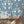 The Great Damask wallpaper by Brand McKenzie in blue, a large-scale damask behind a dining table