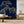 Japanese Tree wallpaper by Dami and Em Design in blue, a Japanese pine tree behind a sofa in a living room