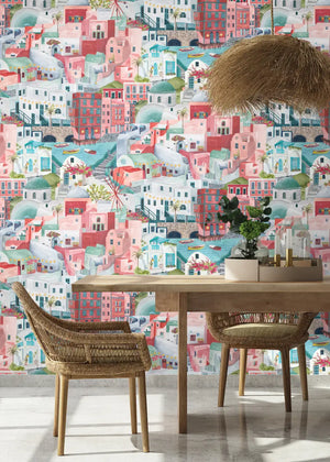 The Mediterranean wallpaper by Brand McKenzie in pink and aqua, a whitewashed hillside village in a dining area