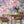 The Mediterranean wallpaper by Brand McKenzie in lilac and pink, a whitewashed hillside village behind a dining table