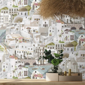 The Mediterranean wallpaper by Brand McKenzie in grey, a whitewashed hillside village behind a dining table