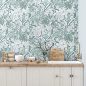 The Tropics wallpaper by Brand McKenzie in mint green, tropical leaves and birds behind a console table