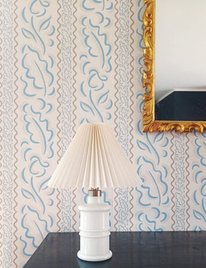 Therese wallpaper by Claire de Quénetain in brown, wavy stripes behind a console table