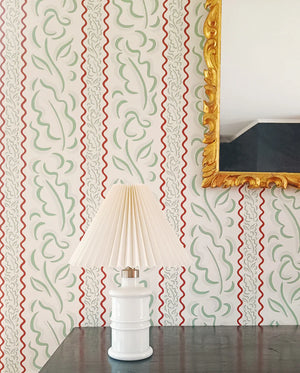 Therese wallpaper by Claire de Quénetain in green, wavy stripes above a sideboard