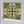 Versailles wallpaper by Liberty James Studio in green and gold, roll showing an ornate kaleidoscope design