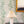 Vivienne wallpaper by Claire de Quénetain in blue and green, bamboo-like leaves above a sideboard