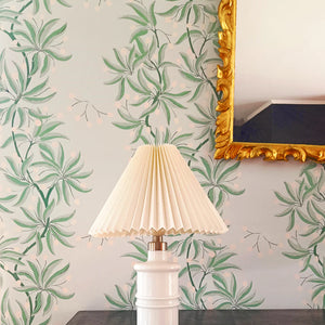Vivienne wallpaper by Claire de Quénetain in blue and green, bamboo-like leaves above a sideboard