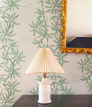 Vivienne wallpaper by Claire de Quénetain in blue and green, bamboo-like leaves above a sideboard