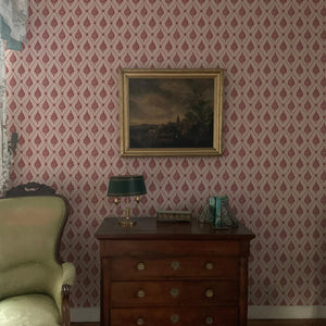 Agra wallpaper by Annika Reed in pink, block-print flowers in a trellis behind a console table