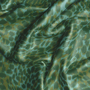 Leopard velvet by Tatie Lou in green, draped close-up of a leopard-spot print