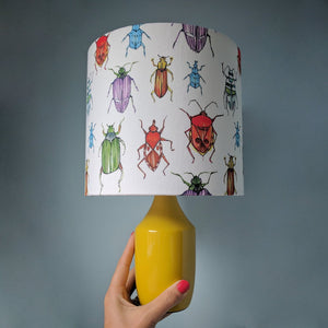 Beetle fabric by Seed Home Designs in red, blue and green, watercolour beetles in a styled room setting