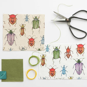 Beetle fabric by Seed Home Designs in red, blue and green, pattern sample of watercolour beetles