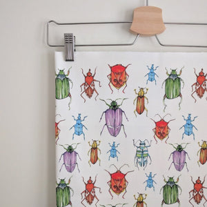 Beetle fabric by Seed Home Designs in red, blue and green, watercolour beetles on a feature wall