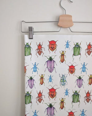 Beetle fabric by Seed Home Designs in red, blue and green, watercolour beetles on a feature wall