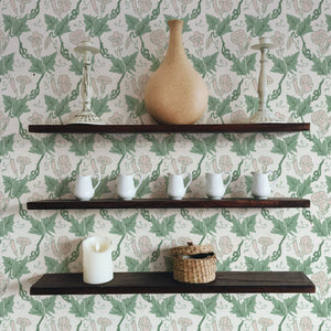 Bindweed wallpaper by Annika Reed in green and pink, trailing bindweed flowers above a sideboard