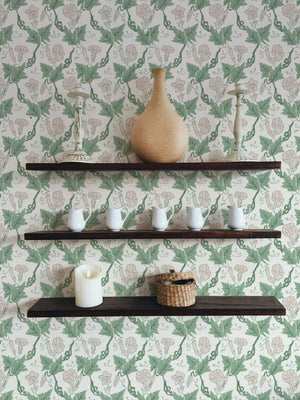 Bindweed wallpaper by Annika Reed in green and pink, trailing bindweed flowers above a sideboard